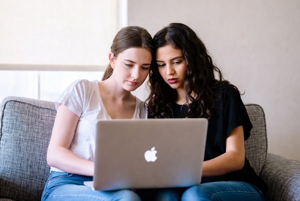 两个女孩在看电脑。