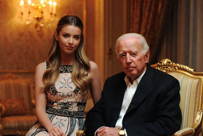 一个女孩正坐在在一位老人身边，陪伴他。